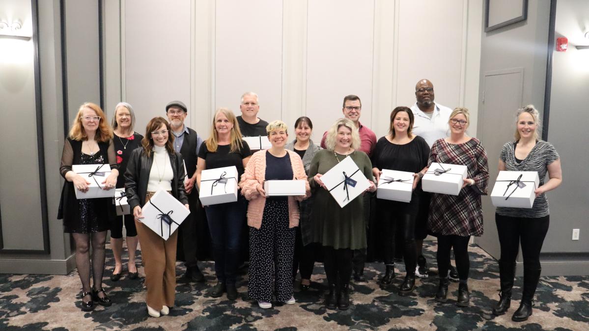Group of employees holding white boxes, celebrating years of service